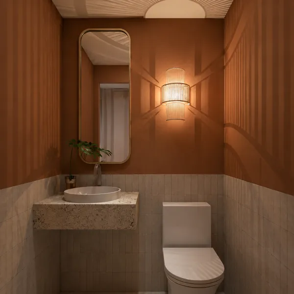 Lavabo com paredes em tom terracota e espelho dourado